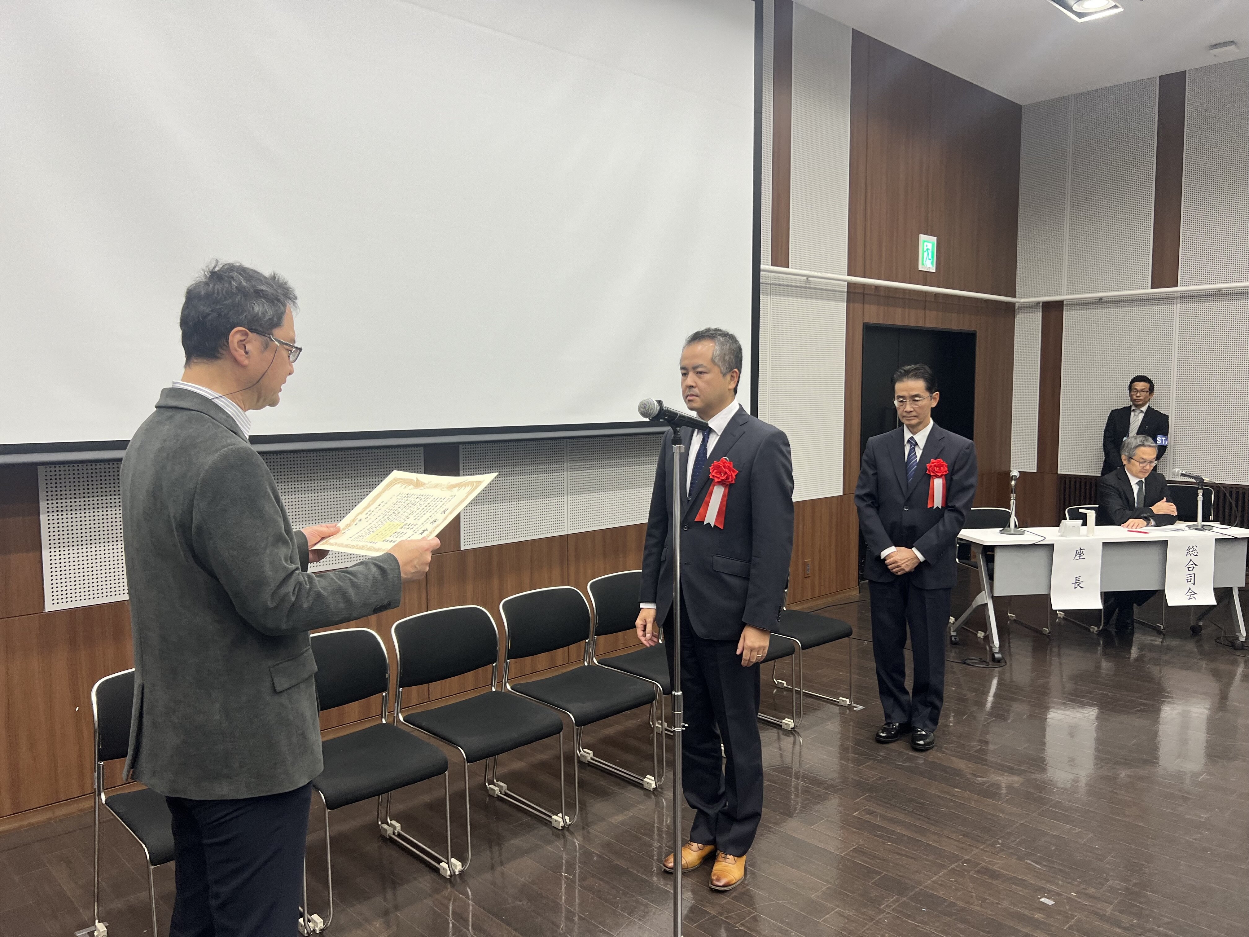 納冨充雄会長から表彰を受ける松井教授と共著者の服部兼久様(東洋精鋼(株))