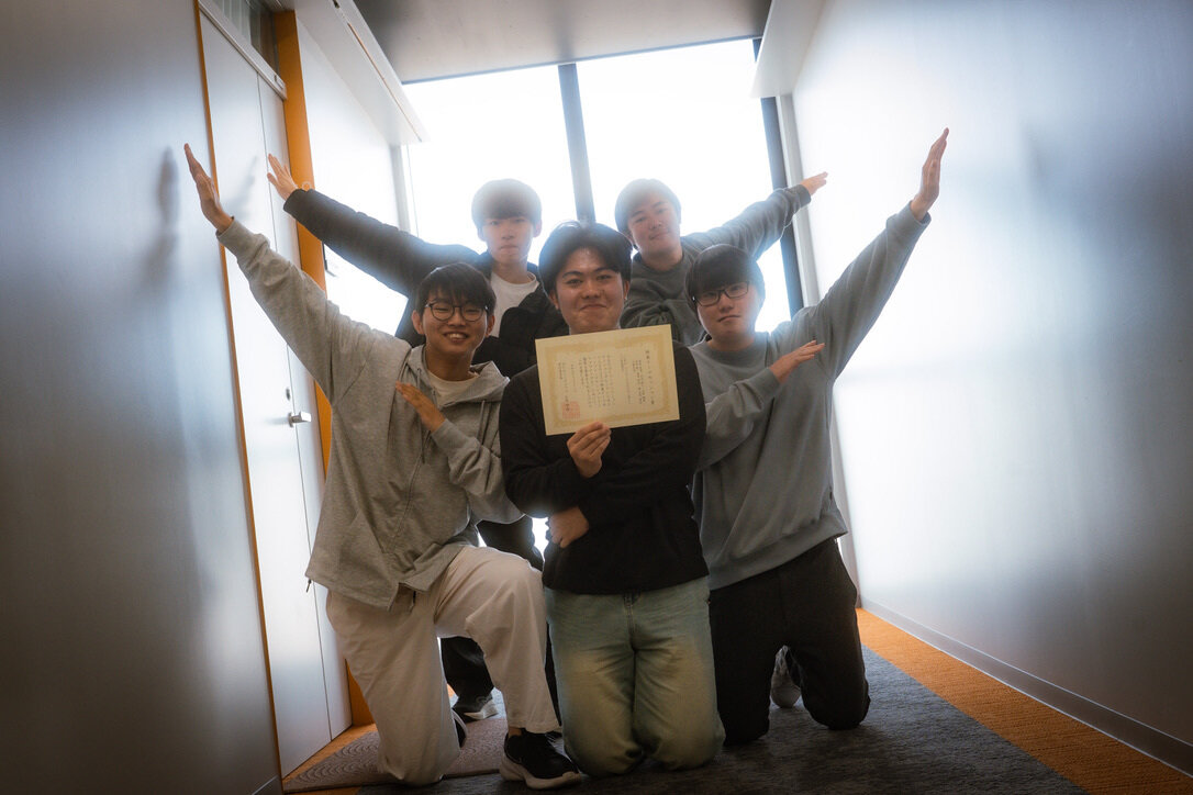受賞者の長尾さんをxDR Challenge 2025に参加したグループのメンバー（左から多田隆人さん、丹羽慧さん、水野楓希さん、酒井翔琉さん）が囲んでいます
