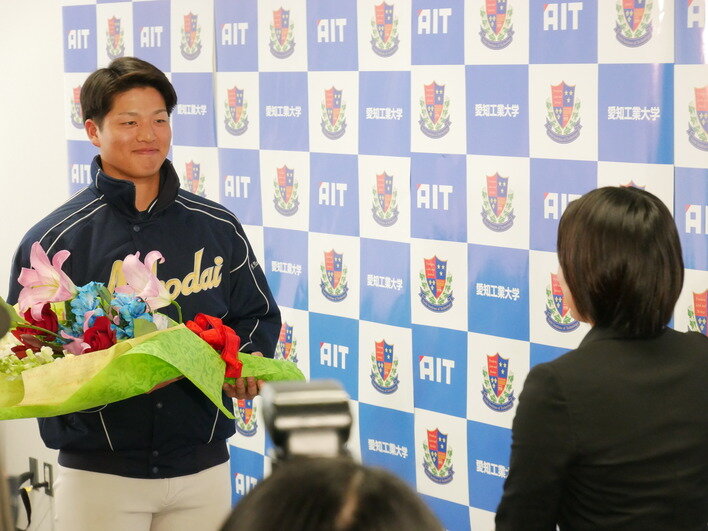 笑顔で花束を受け取る中村投手